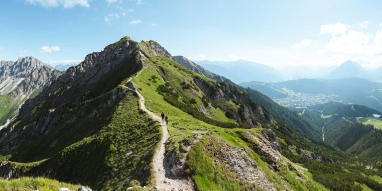 Wanderer auf dem Weg auf die Seefelder Spitze - Blick ins Karwendelgebirge und die Region Seefeld - Panoramabild
